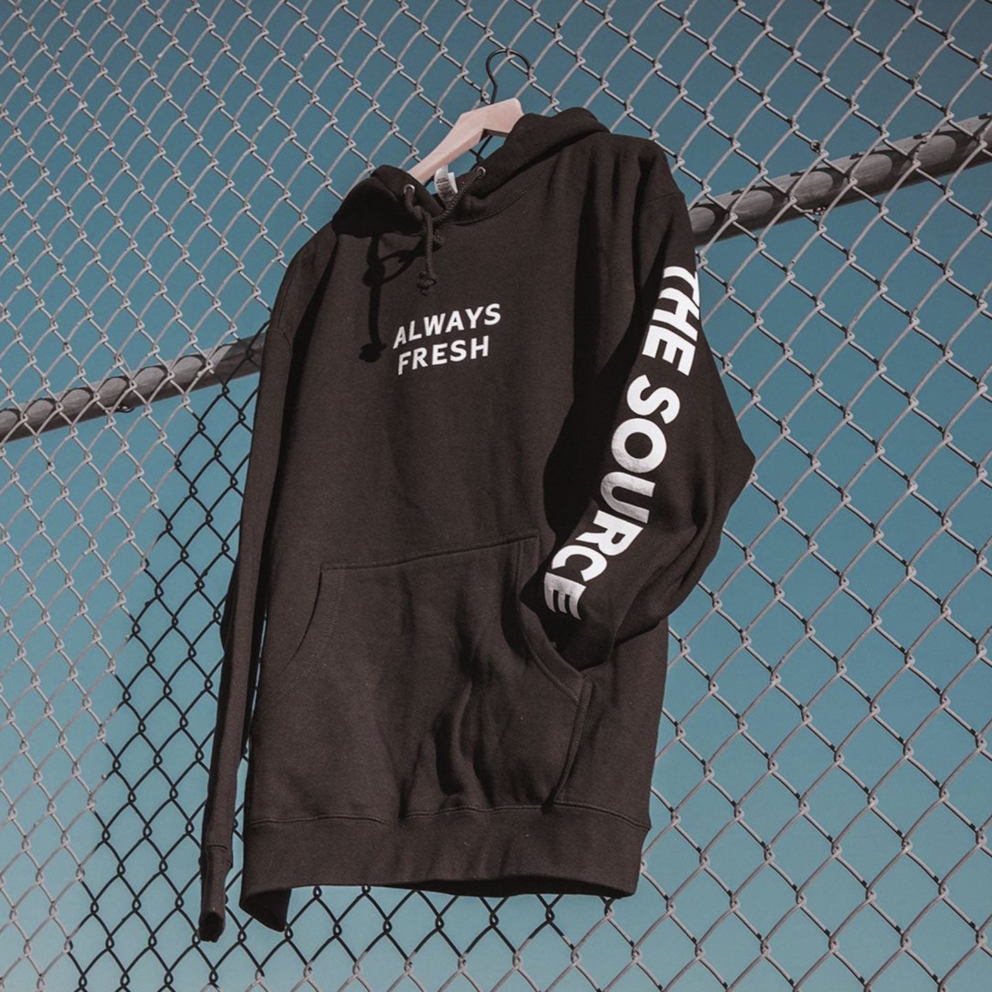 the source custom sweatshirt displayed on a chainlink fence that says "always fresh"